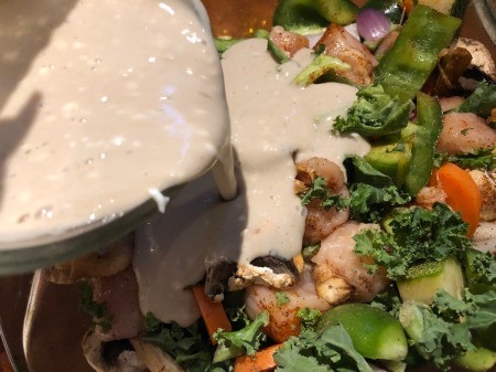 pouring sauce on veggies & chicken