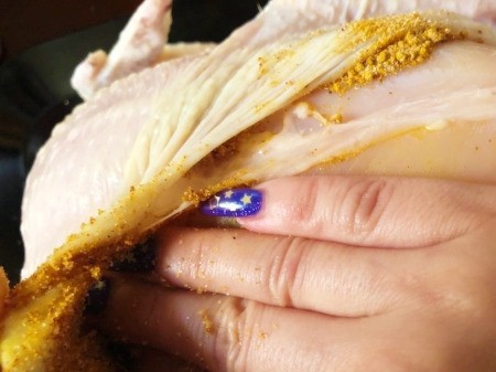 rubbing spices under chicken skin