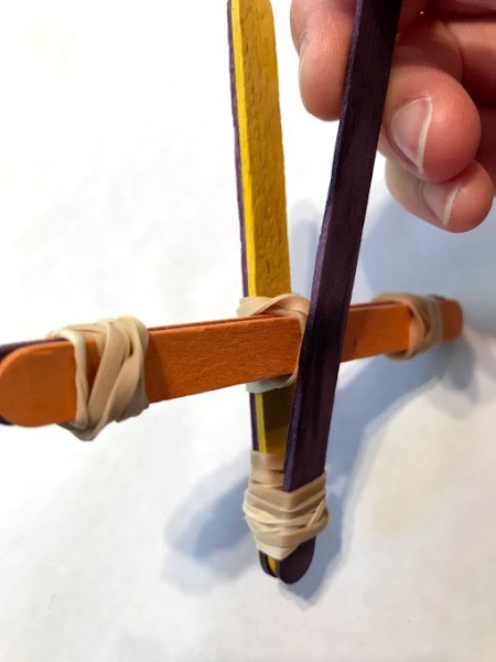 Making a Craft Stick Catapult for Kids - pulling purple stick out
