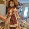 Identifying a Porcelain Doll - doll wearing long dress of brown and floral fabric with eyelet lace trim and matching hat