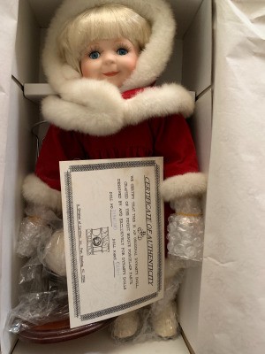 Value of a Dynasty Porcelain Doll - doll in box wearing a red coat with white fur trim