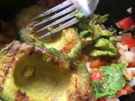 adding avocado to chopped veggies