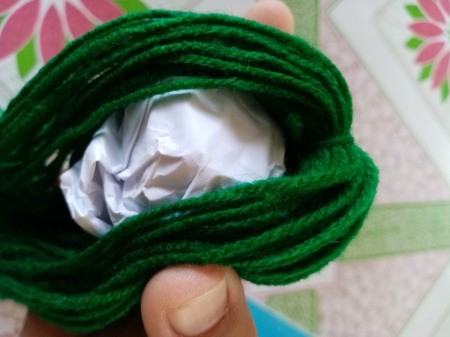 Mr. Octopus Made of Yarn - placing ball of paper in the yarn