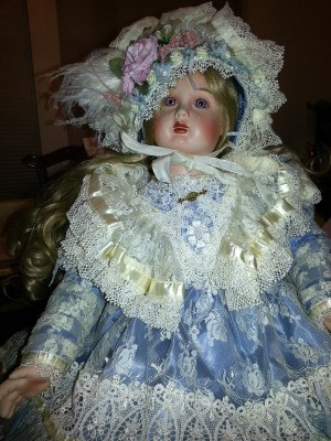 Identifying a Porcelain Doll - doll wearing ice blue dress and matching hat with lots of lace trim