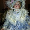 Identifying a Porcelain Doll - doll wearing ice blue dress and matching hat with lots of lace trim