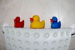 A rubber bathmat and three rubber duckies.