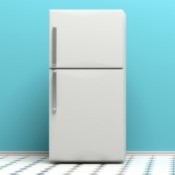 A white refrigerator with a teal wall behind.