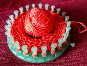 A round knitting loom in use.