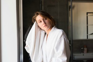 A woman drying her hair with a towel.