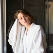 A woman drying her hair with a towel.