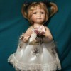 Value of a Geppeddo Doll - red head doll in white lace and satin dress holding a flower