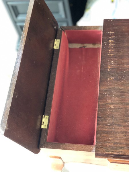 An open drawer of a vintage table.