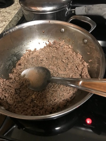 Cooking ground beef in a frying pan.