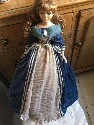 Identifying French Porcelain Dolls - doll with hair in long ringlets wearing a blue dress with white underskirt