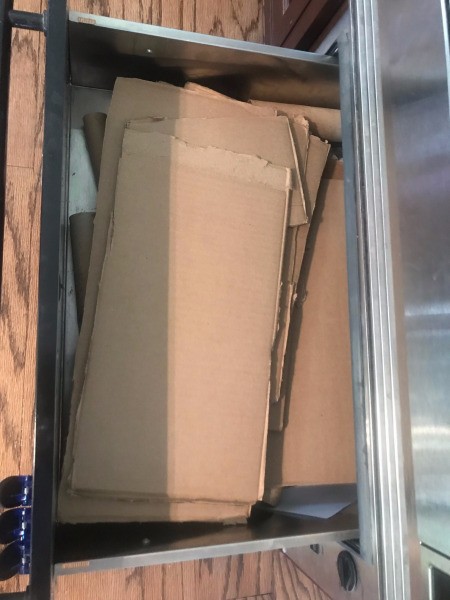 Several cut cardboard pieces in a drawer.