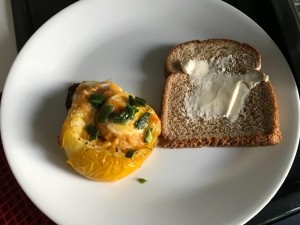 Baked Egg in a Tomato on plate with bread slice