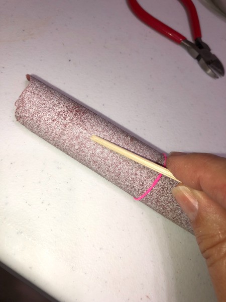 Sanding down the point on a bamboo skewer to use as a cuticle stick.