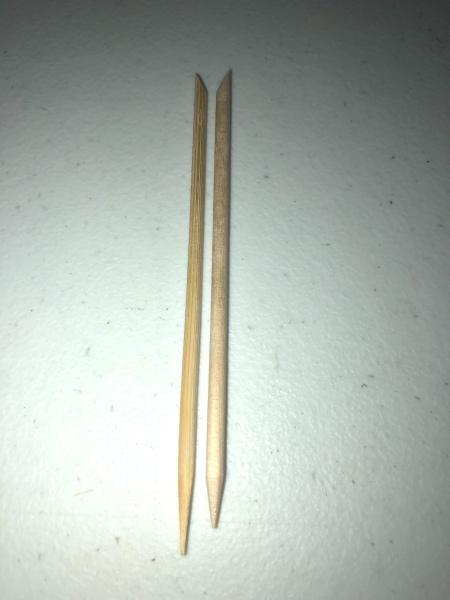 A homemade bamboo cuticle stick next to a store bought one.