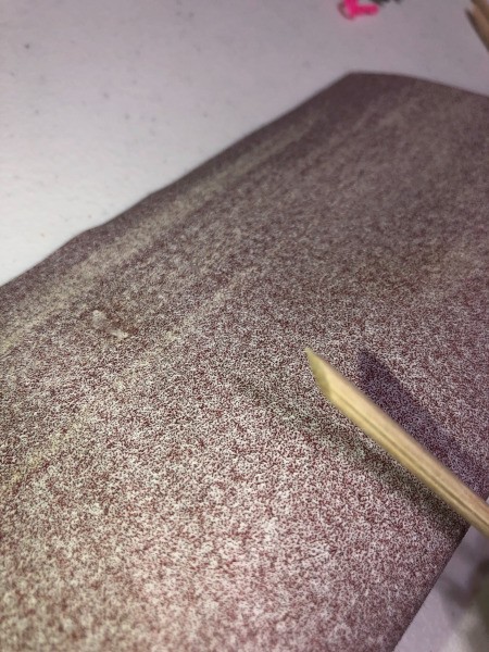 A sanded cuticle stick made from a skewer.