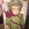Value of a Collector's Choice Porcelain Doll - doll wearing a green coat with plum trim and matching hat