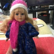Value of a Collector's Choice Doll - doll wearing a pink and white knit hat and scarf with a dark blue dress with snowflakes