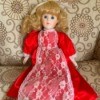 Identifying a Porcelain Doll - doll in red dress with lace apron