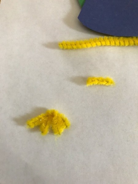 Peacock Popsicle Stick Puppet - V shaped pieces twisted together for feet