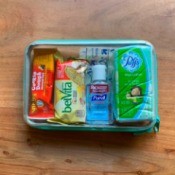 A clear container storing emergency supplies for a child going to school.