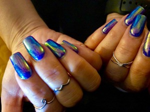 Long nails beautifully manicured with an opalescent blue polish.