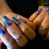 Long nails beautifully manicured with an opalescent blue polish.