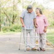 An elderly couple walking in the park.