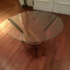 Value of a Vintage Round Glass Topped Table - round glass topped table with wood base including a shelf and three legs
