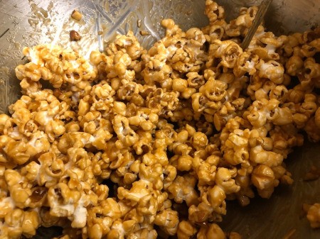 mixing caramel on popcorn