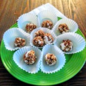 A plate of pecan log balls served on white liners.