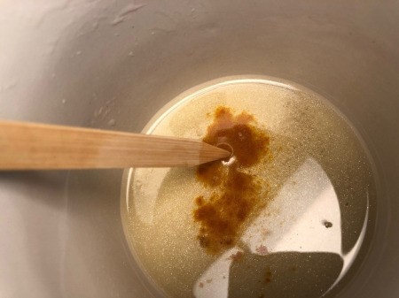 How to Make Natural Tinted Lip Balm - add tumeric to the remaining mixture in the double boiler and stir well