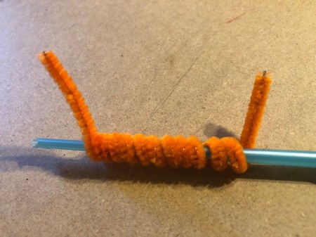 Pipe Cleaner Pumpkin Craft - orange pipe cleaner twisted around a paint brush handle