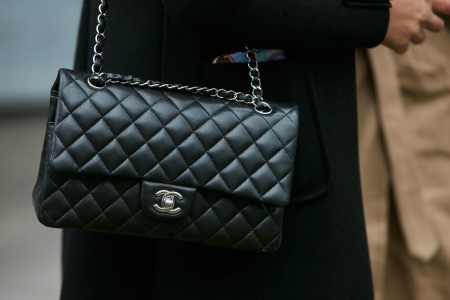 A woman holding a Chanel handbag.