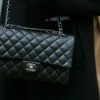 A woman holding a Chanel handbag.