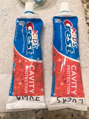 Two tubes of toothpaste with names marked on them.