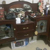 Value of an Vintage Sideboard  - dark wood sideboard with leaded glass doors and an oval rear mirror