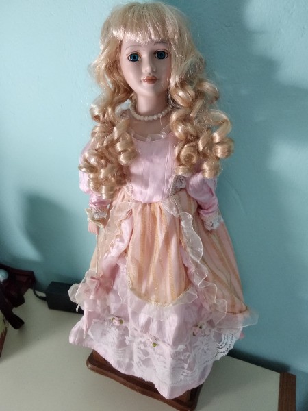 Identifying a Porcelain Doll - doll with long blond ringlets wearing a peach dress with white lace trim