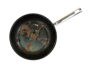 A dirty nonstick frying pan with a greasy residue.
