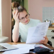 A stressed woman looking at paperwork.