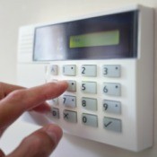 Fingers pressing buttons on an alarm system.