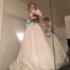 Value of an Ashton Drake Doll - doll wearing a long white dress with a blue sash in a clear doll display case