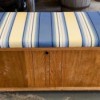 Value of a Lane Cedar Chest - medium wood finish chest with blue, black, white, and yellow striped cushion