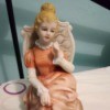 Identifying a Porcelain Figurine - woman in period clothing with hair in a bun sitting on an upholstered style chair