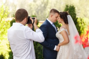 A photographer taking pictures of a couple on their wedding day.