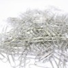 A pile of silver paper clips on a white background.