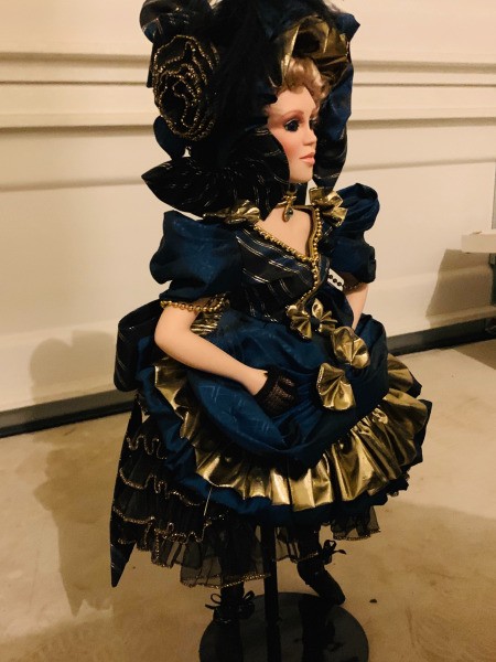 A porcelain doll in a black outfit.